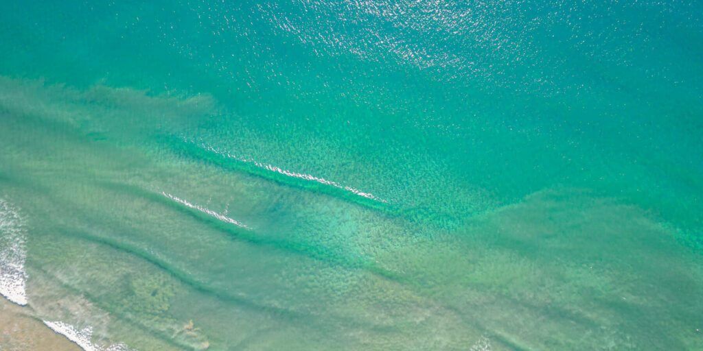 Bãi biển có khả năng thay đổi màu nước đầy kỳ ảo. Vào buổi sáng, nước biển có màu xanh lục và dần chuyển sang màu xanh ngọc bích vào lúc chiều tà.