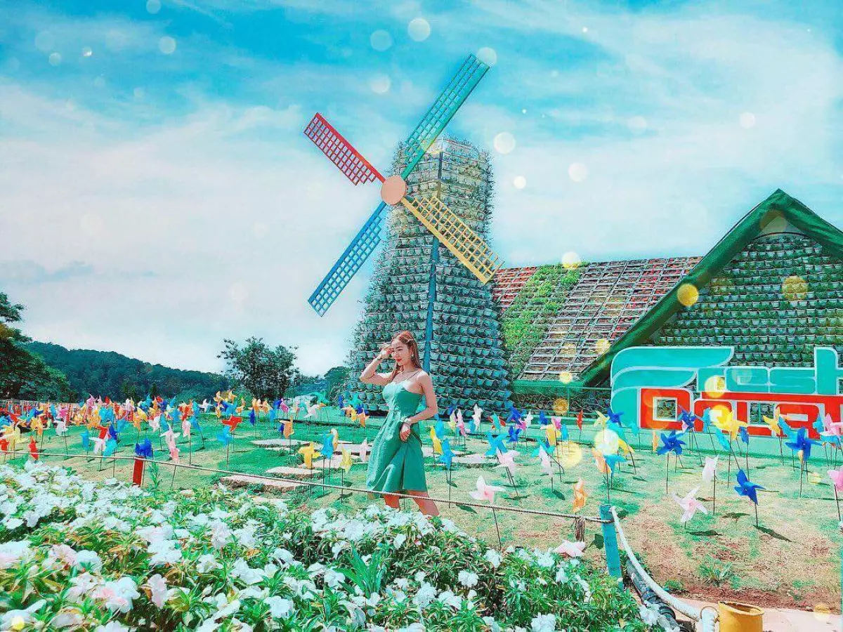 広い花畑の真ん中に色とりどりの風車が映えるイメージ